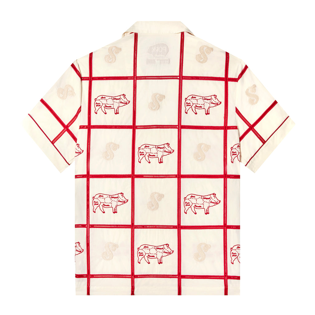 Backwards-facing product image of 'The Sopranos' Satriale's (Gabagool) that features a cream base, square panels joined by red ‘ladder’ lace embroidery, red piping on cuffs and pocket strips, pig embroidery on alternating panels, labeled with various cuts in Sopranos parlance: "gabagool", "pruh-zhoot", etc, chain-stitched Satriale's logo on side panels, shot on a white background.
