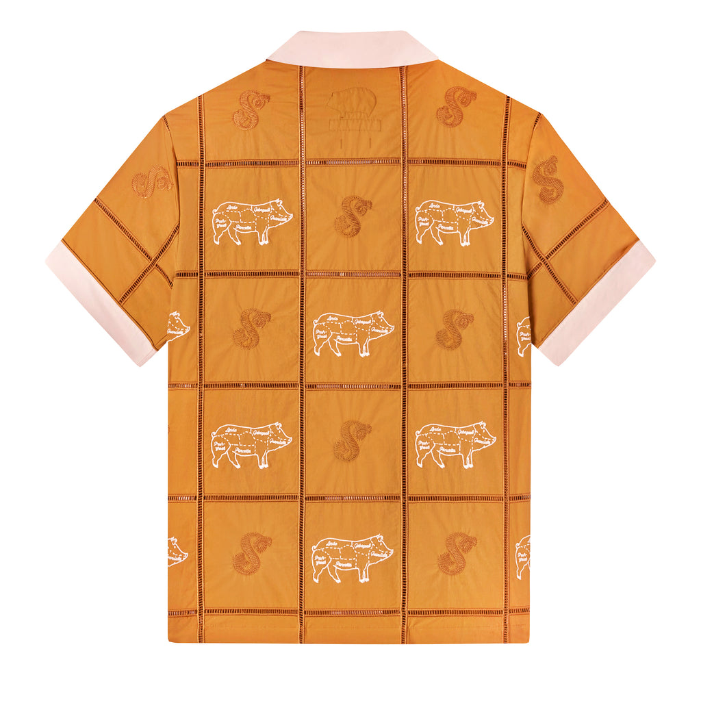 Backwards-facing product image of 'The Sopranos' Satriale's (Pruh-Zhoot) showcasing the pig embroidery on alternating panels, labeled with various cuts in Sopranos parlance: "gabagool", "pruh-zhoot", etc, and square panels joined by ‘ladder’ lace embroidery