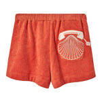 Back view of orange terry cloth shorts featuring a white embroidered rotary phone with a seashell design on the right side.