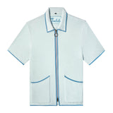 Front-facing product image of the 'Standard Issue' Cabana (Sky Blue) made of 100% Organic Terry Cloth with a two-way, antique-brass ring pull zipper, twin curved patch pockets, chain-stitched Tombolo interior label, and a 1/8" edge binding along collar, zipper, and pockets, all shot on a white background.