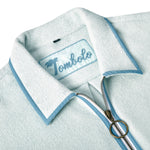 Close-up image of the 'Standard Issue' Cabana's (Sky Blue) interior chain-stitched label that says 'Tombolo,' and the antique brass two-way ring pull zipper. 