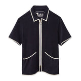 Front-facing product image of the 'Standard Issue' Cabana (Midnight Blue) made of 100% Organic Terry Cloth with a two-way, antique-brass ring pull zipper, twin curved patch pockets, chain-stitched Tombolo interior label, and 1/8" edge binding along collar, zipper, and pockets, all shot on a white background.