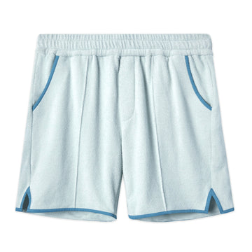 Front-facing product image of the 'Standard Issue' Cabana Shorts (Sky Blue) made of 100% Organic Terry Cloth with an elastic waistband, pull-on style with relaxed fit throughout, 1/4" edge-binding on pocket and leg openings (including v-slit on side seam), signature Tombolo v-slit back pocket, sewn pleats, and an Internal drawstring