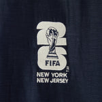 Embroidered FIFA logo on a navy fabric.