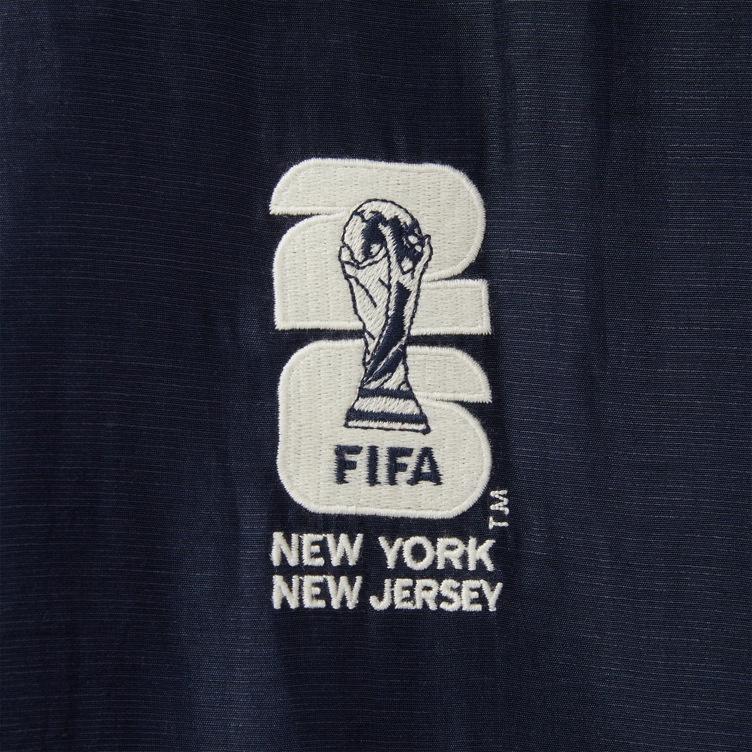 Embroidered FIFA logo on a navy fabric.