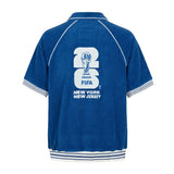 Back view of blue terry cloth short sleeve cabana shirt with large FIFA World Cup 26 New York New Jersey embroidery.
