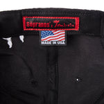Inside of 'The Sopranos' 25th Anniversary 5-Panel Souvenir Cap that features a  Custom Sopranos x Tombolo interior label and "Made in USA" tag with an American flag.