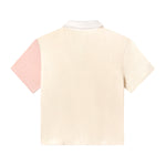 Back of conched out terrycloth crop cut in beige with left sleeve in coral pink