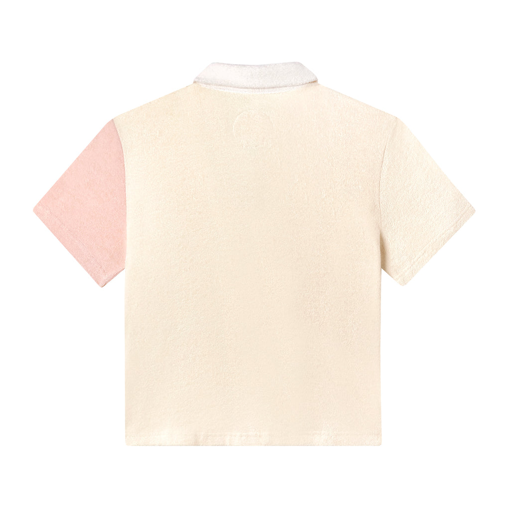 Back of conched out terrycloth crop cut in beige with left sleeve in coral pink