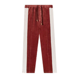 Front-facing product image of 'The Sopranos' Pie-O-My Track pants made of Organic Cotton Velour that features a burgundy and pink velour paneling, sewn pleats, an elasticized waist linked to drawstrings with varnished wood stoppers, and concealed pocket on side seam.