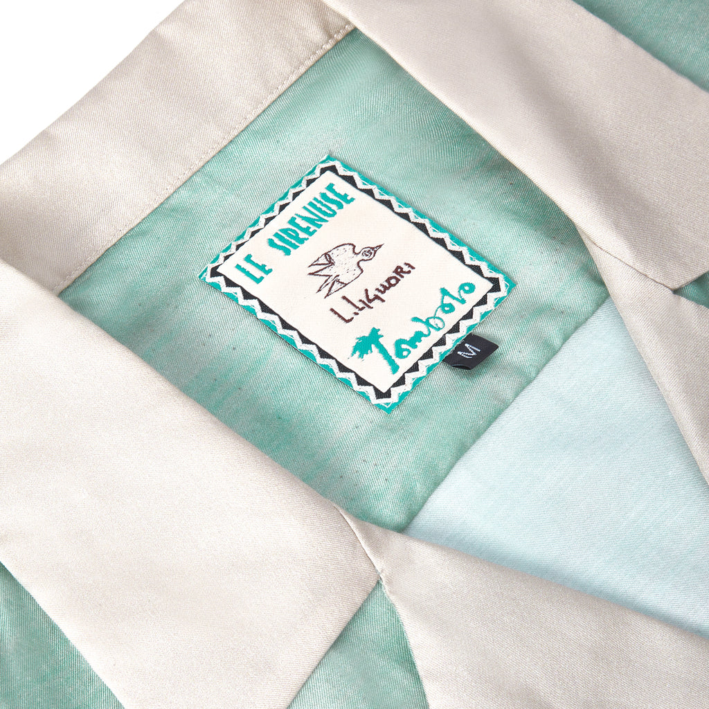 Close up of label for Tombolo's collaboration with Le Sirenuse highlighting the artist Lucio Liguori