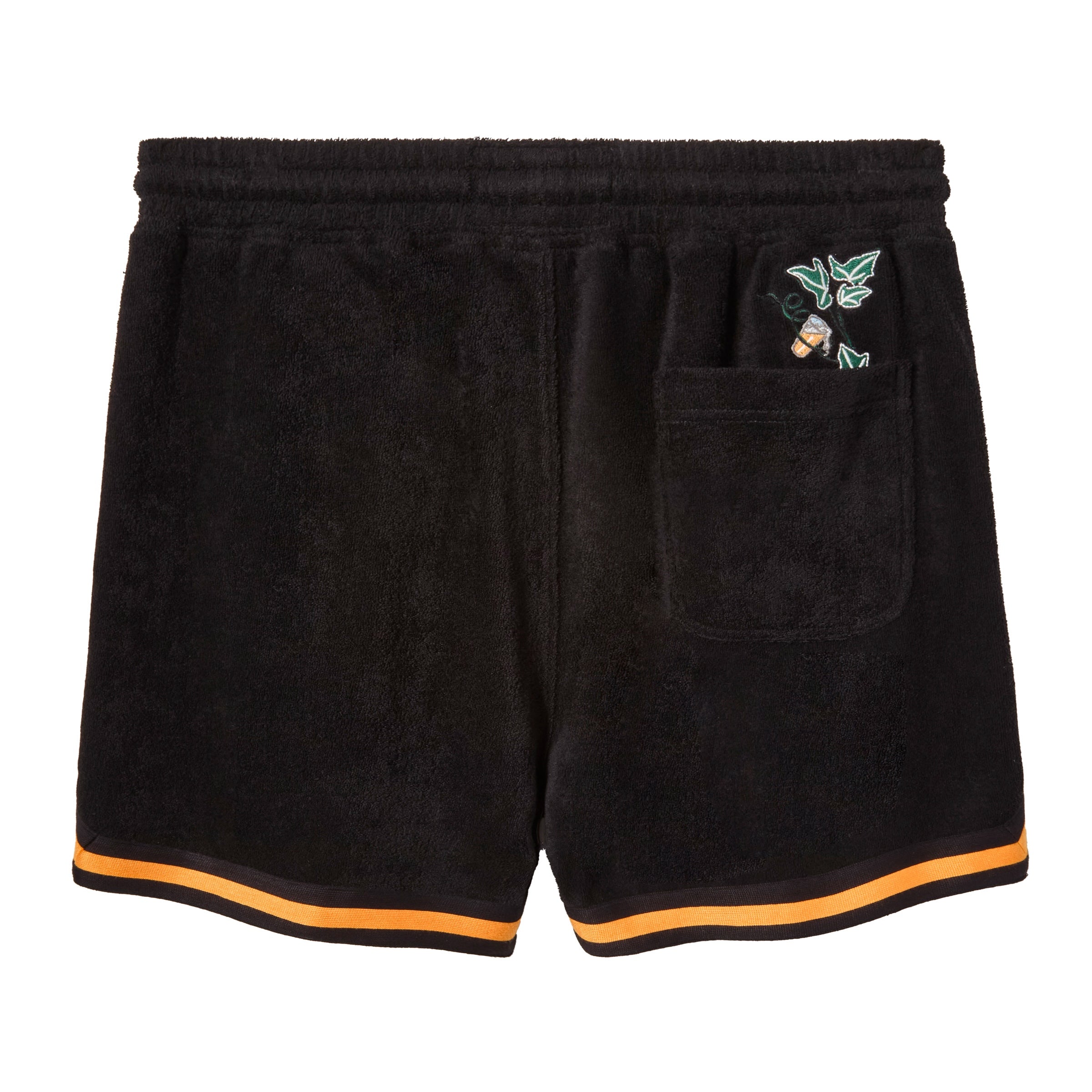 Backside of Black terry cloth shorts with an elastic waistband. Features a back pocket, with greenery and an orange beverage poking out the top.