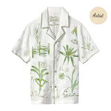 A short-sleeve white button-down shirt with green botanical and abstract designs.