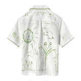 Image of backside of white button down, featuring more green floral and abstract designs. 