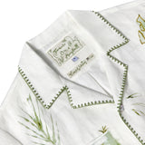 Close-up of Tombolo & Mary Ball interior label, featuring green flower drawings. 