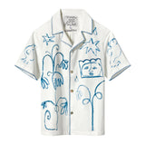 White short-sleeve shirt with blue line art of abstract faces, plants, and animals. Blue stitching decorates the edges.