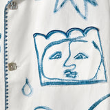 Detail shot of one of the abstract faces on the 'Seasons of Change' by Mary Ball Shirt. 
