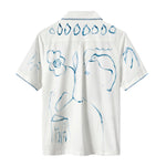 The back of a white short-sleeve shirt featuring abstract blue brushstroke designs of flowers, birds, and leaves, with a row of teardrop shapes across the upper back and stitched trim on the sleeves.
