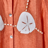 Close-up of the cream sand dollar, with cowrie shells replicating bikini strings. 
