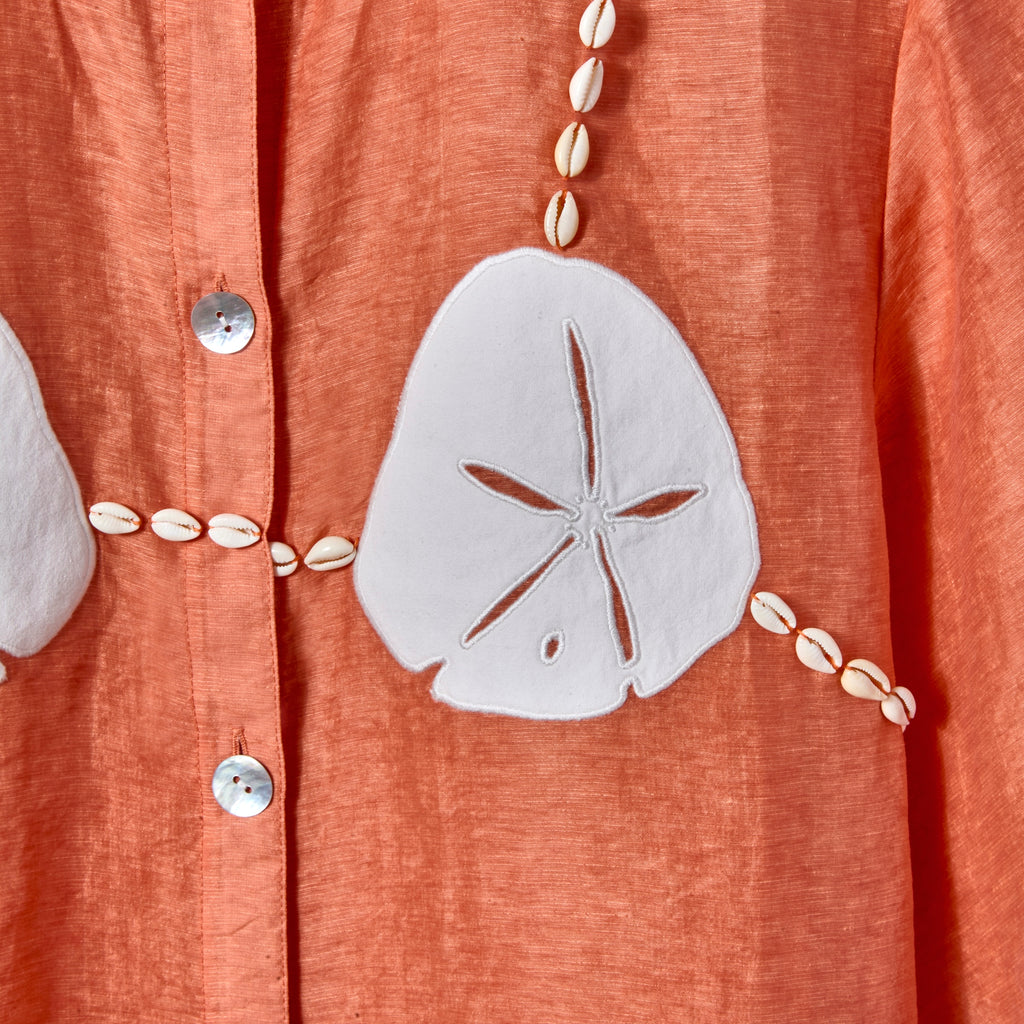 Close-up of the cream sand dollar, with cowrie shells replicating bikini strings. 