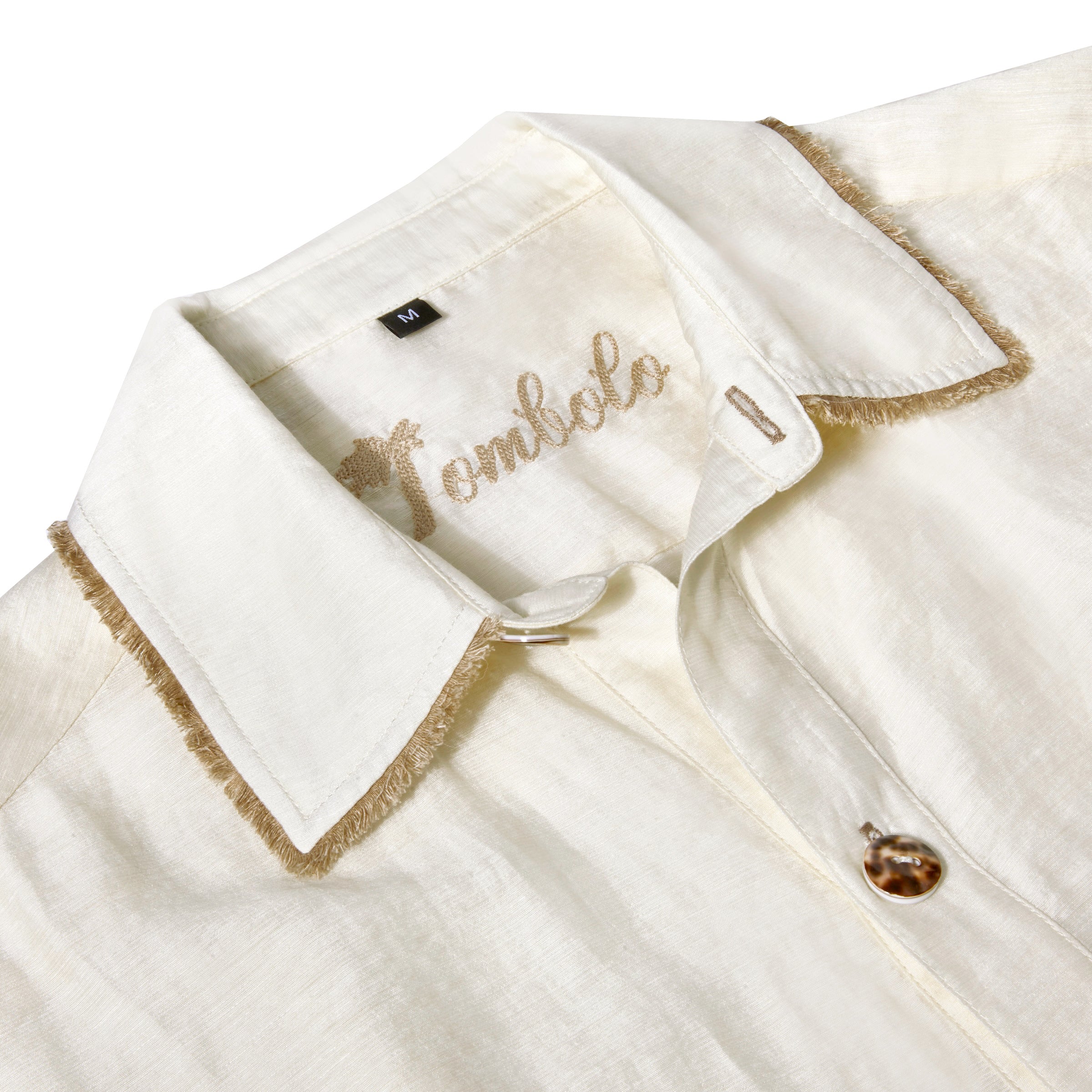 close up of collar, button, fringe trim, and Tombolo interior chain stitching on shirt