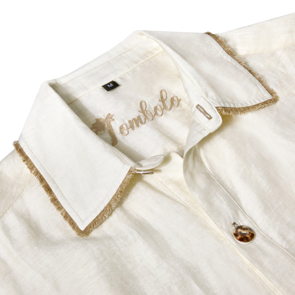 close up of collar, button, fringe trim, and Tombolo interior chain stitching on shirt