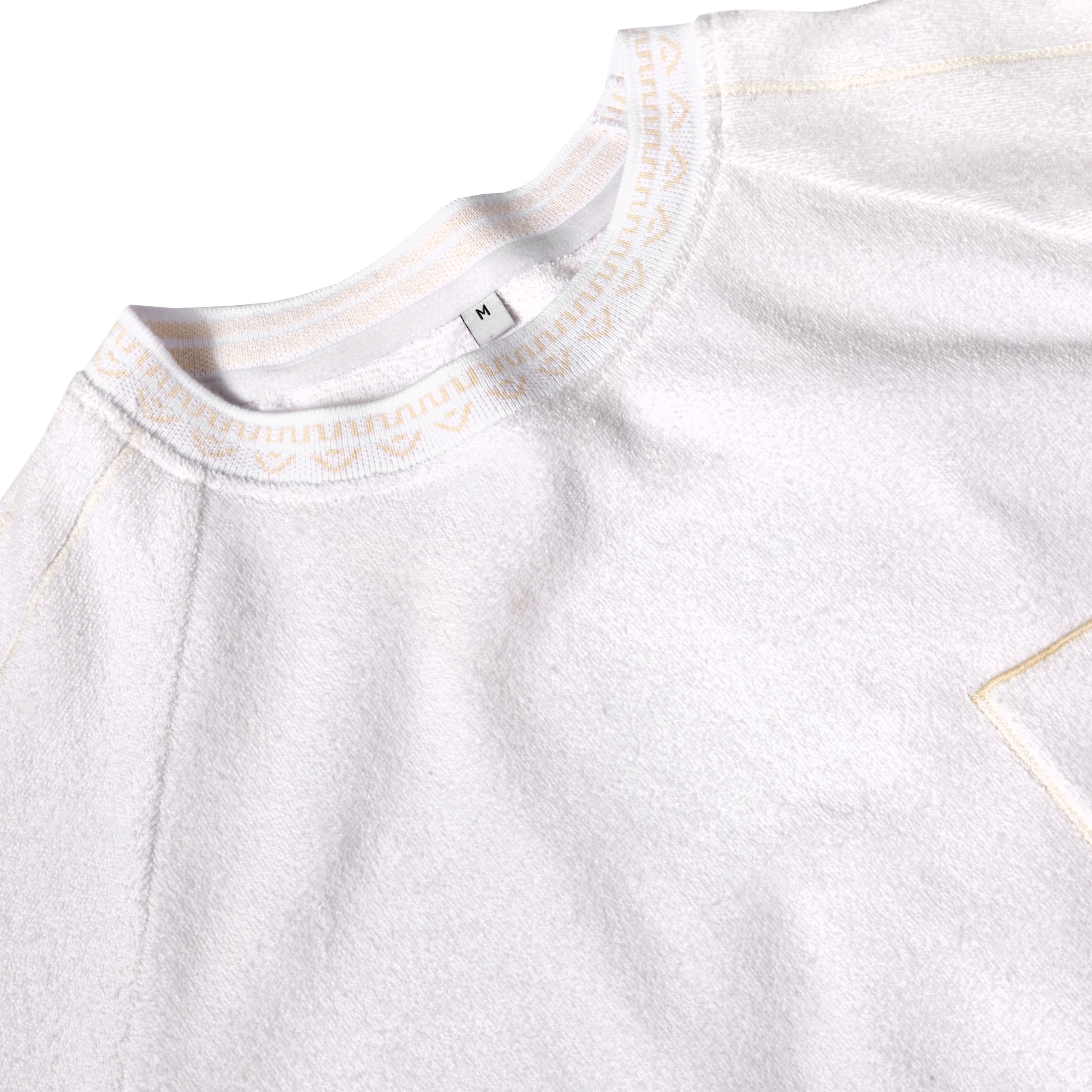 Close-up detail shot of the collar on the white terry tee.