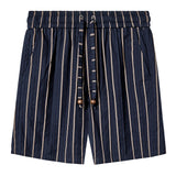 Front-facing image of navy shorts with beige vertical stripes, an elastic waistband, side pockets, and a striped drawstring with wooden bead accents.