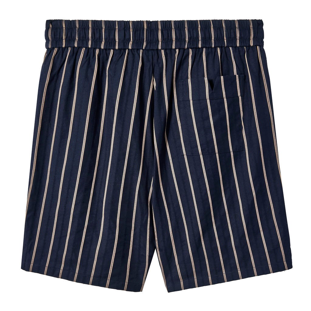 image of backside of navy shorts with beige vertical stripes, an elastic waistband,  and a back pocket on the right side. 