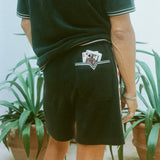 Close-up shot behind a man wearing the 'Vicey Dicey' Shorts, with his hip popped to the right.