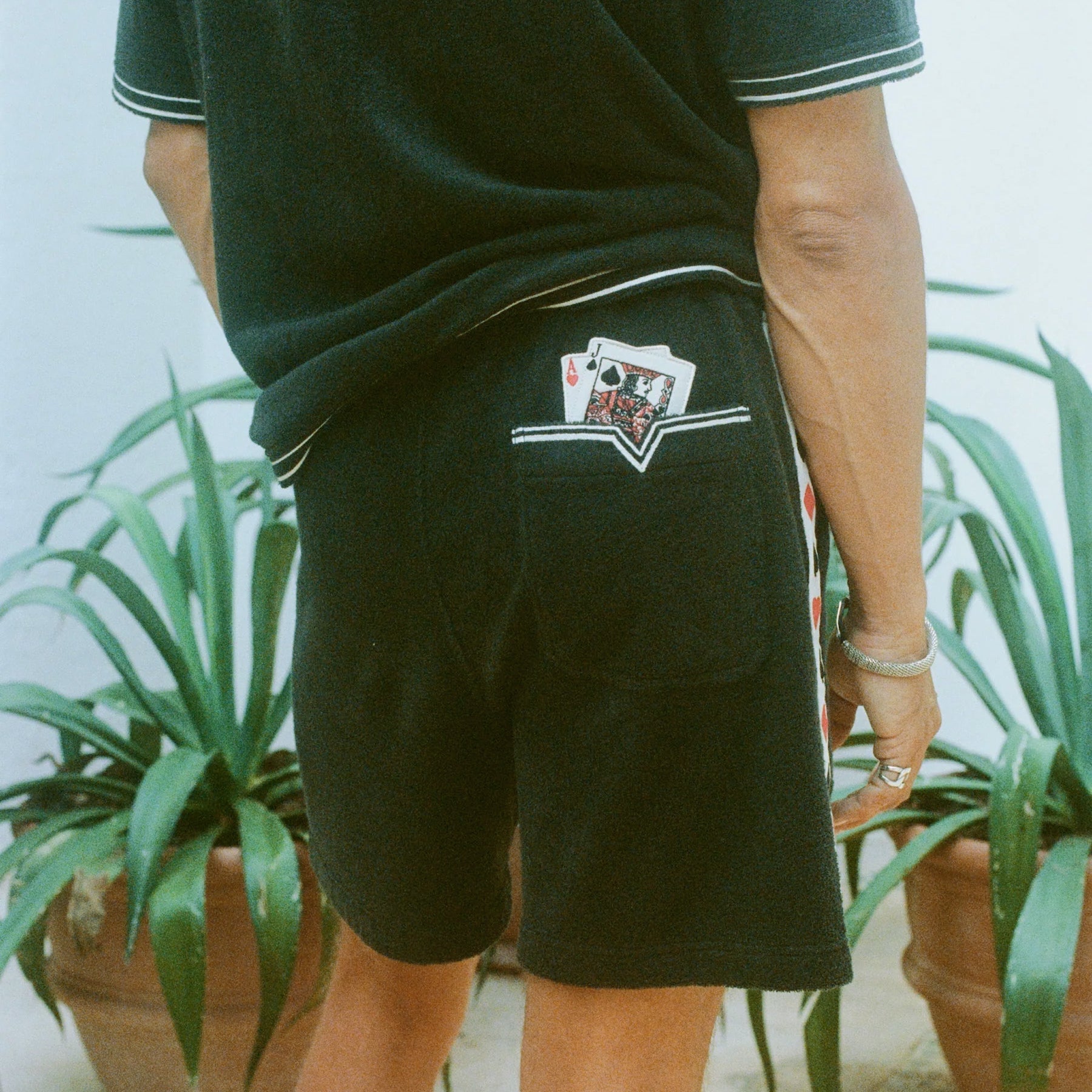 Close-up shot behind a man wearing the 'Vicey Dicey' Shorts, with his hip popped to the right.