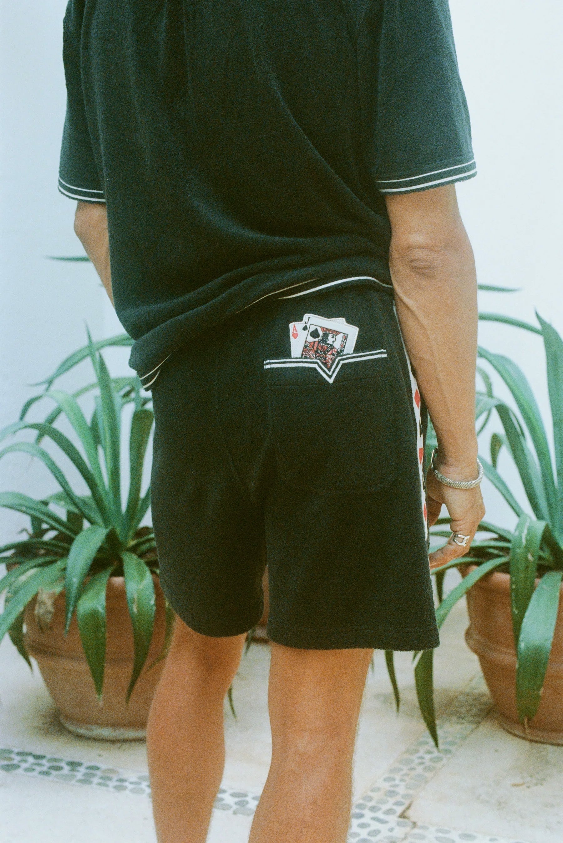 Close-up shot behind a man wearing the 'Vicey Dicey' Shorts, with his hip popped to the right.