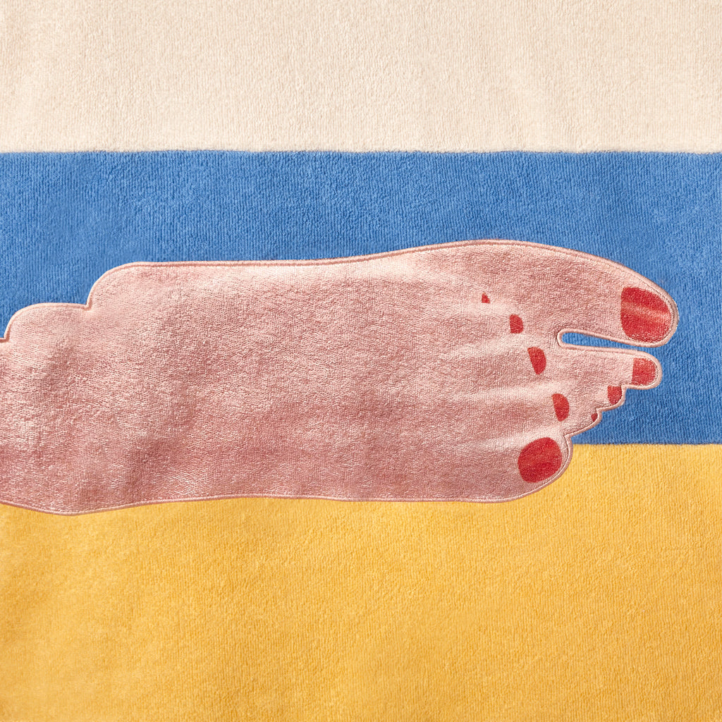 Close up of embroidered feet motif on shirt