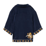 Navy blue garment with gold octopus design and 'SIRENUSE' text across the bottom sweep.