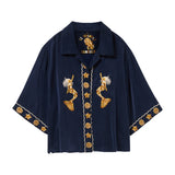 Navy blue shirt with gold mermaid and starfish designs on a white background