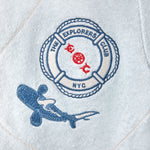 Detail shot of the chest patch featuring a Life Raft, with “The Explorers Club NYC,” the letters “E” and “C,” and a small shark illustration.