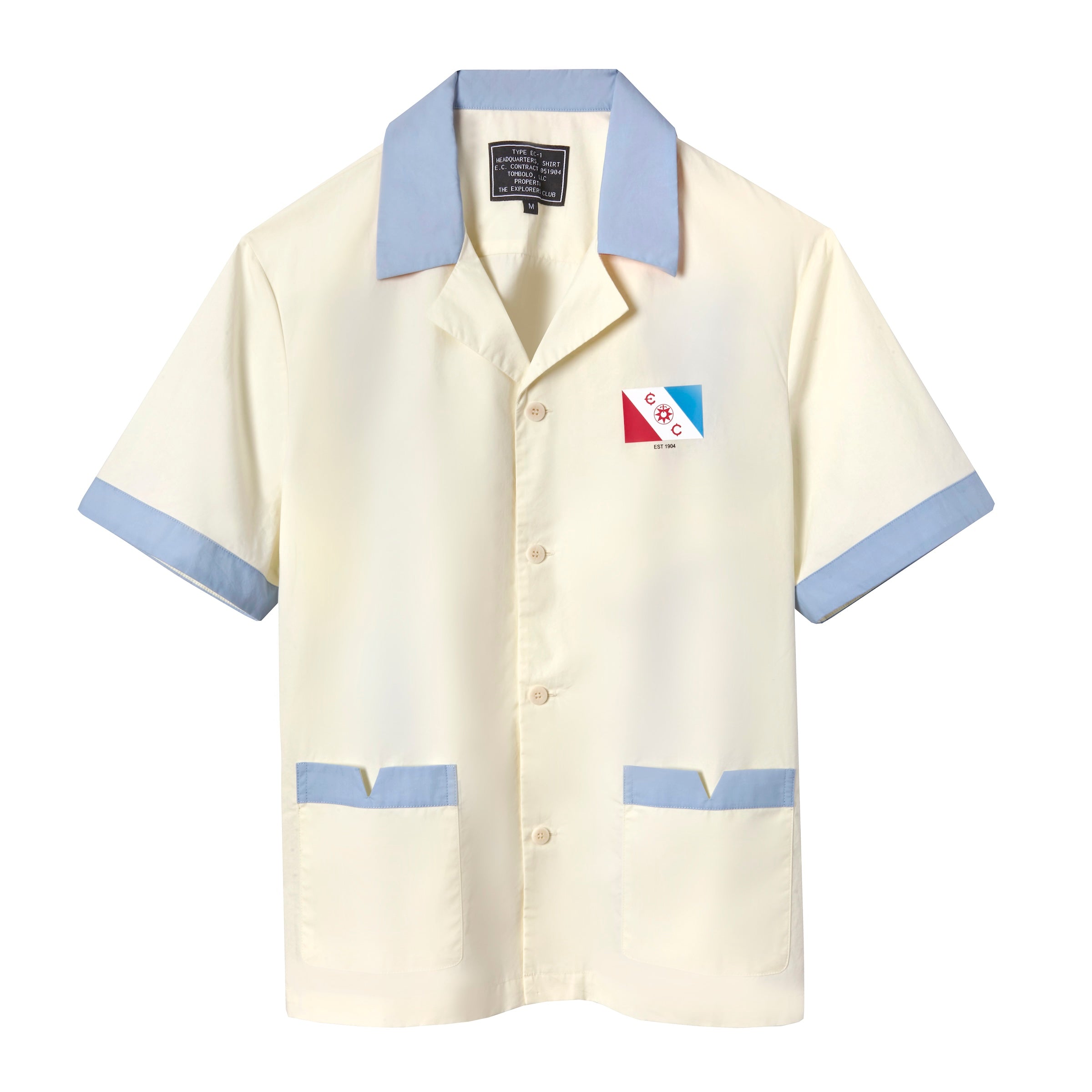 Short-sleeved cream button-up shirt with light blue trim on the collar, sleeves, and pockets. A red, white, and blue patch on the left chest features the letters “E” and “C” with a ship wheel in the center