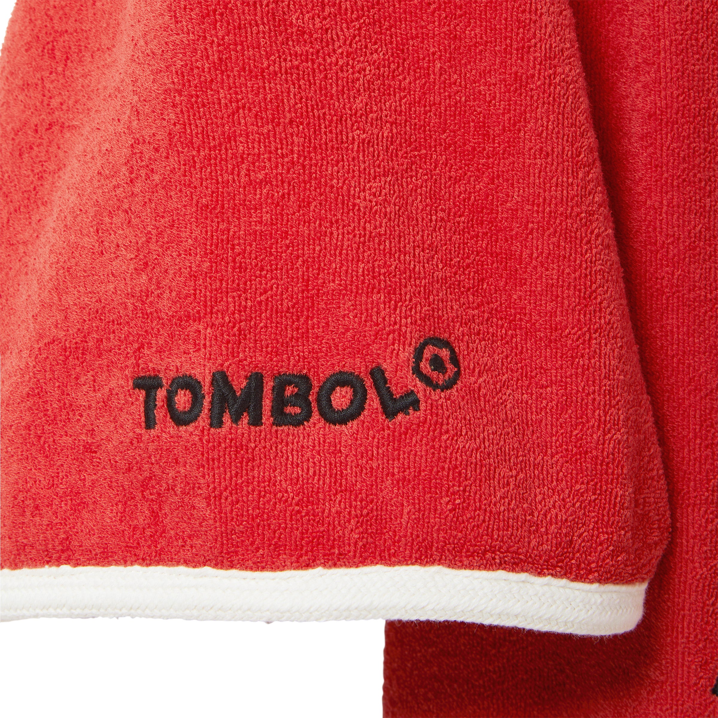 Close-up of red cabana with 'Tombolo' logo on one of the sleeves. 