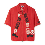 Red shirt with FIFA World Cup and New York/New Jersey text written virtically, to mimic legs in motion.