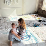 Mary Ball sitting in her studio, with her baby on her lap.