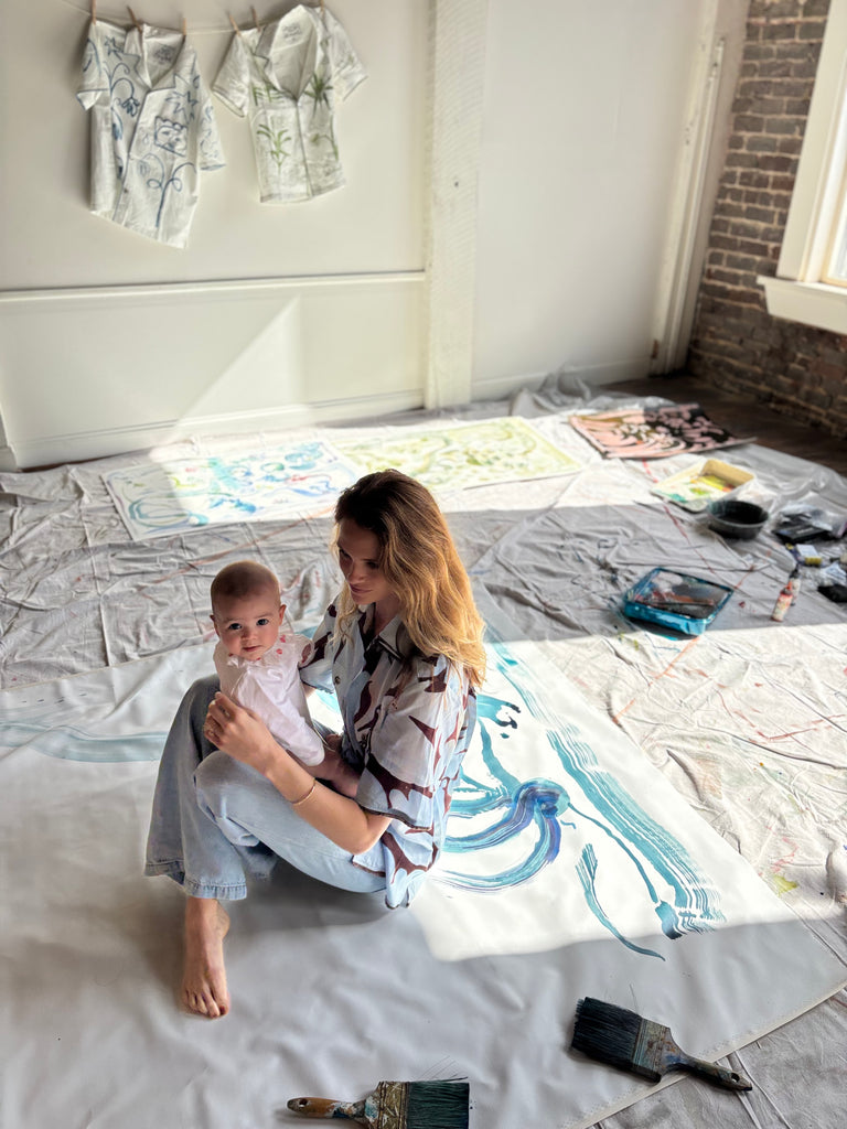 Mary Ball sitting in her studio, with her baby on her lap.