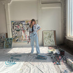 Mary Ball looking down at her paints, in her art studio.