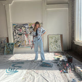Mary Ball looking down at her paints, in her art studio.