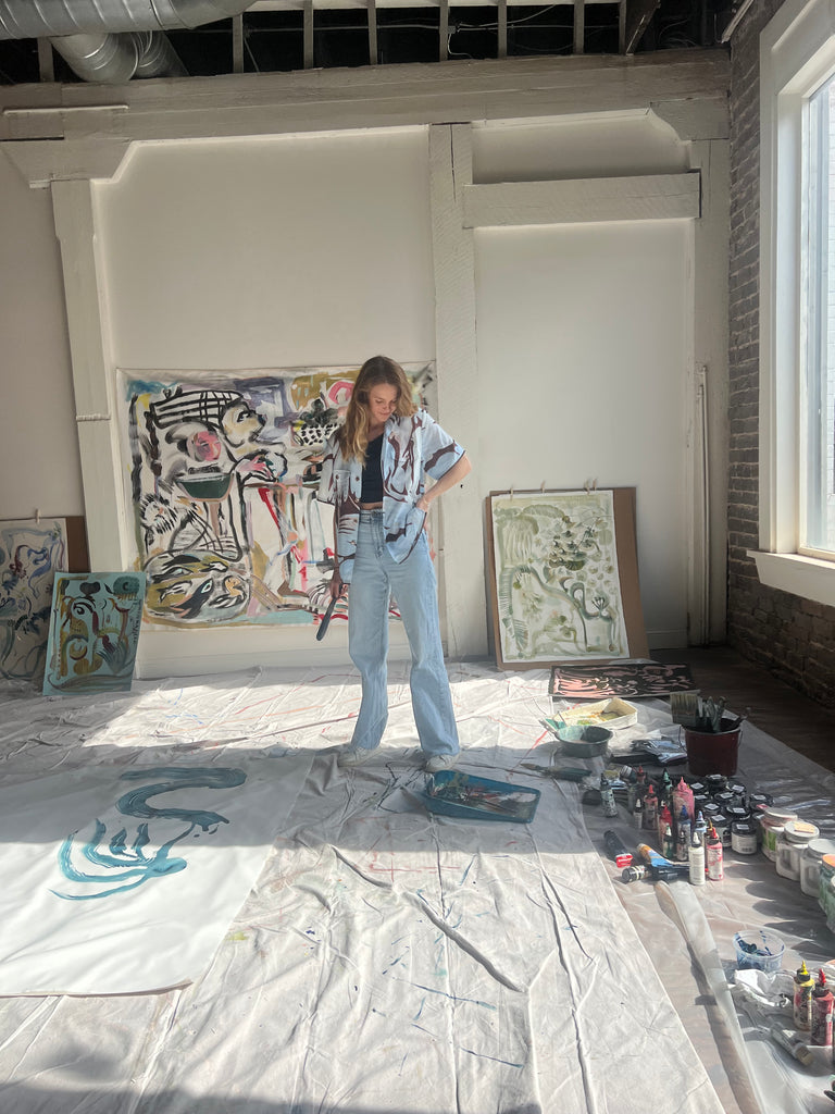 Mary Ball looking down at her paints, in her art studio.