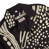 Close-up of black cabana shirt collar with cream chain-stitch embroidery in a loon-inspired dotted pattern and button front.