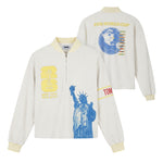 Front and back view of a cream terry long-sleeve quarter-zip featuring striped rib-knit collar and cuffs, embroidered FIFA World Cup 26 New York/New Jersey crest, oversized Statue of Liberty graphic, Tombolo sleeve detail, and a back graphic of a globe-shaped soccer ball.