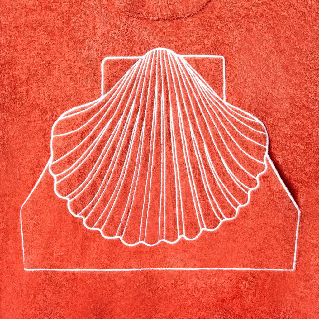 Close-up product image of the 'Scallop' Beach Towel Top's edge-embroidered scallop shell-shaped kangaroo pocket.