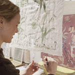 Video of artist Mary Ball signing her autograph on the bottom of the glass case displaying her work.