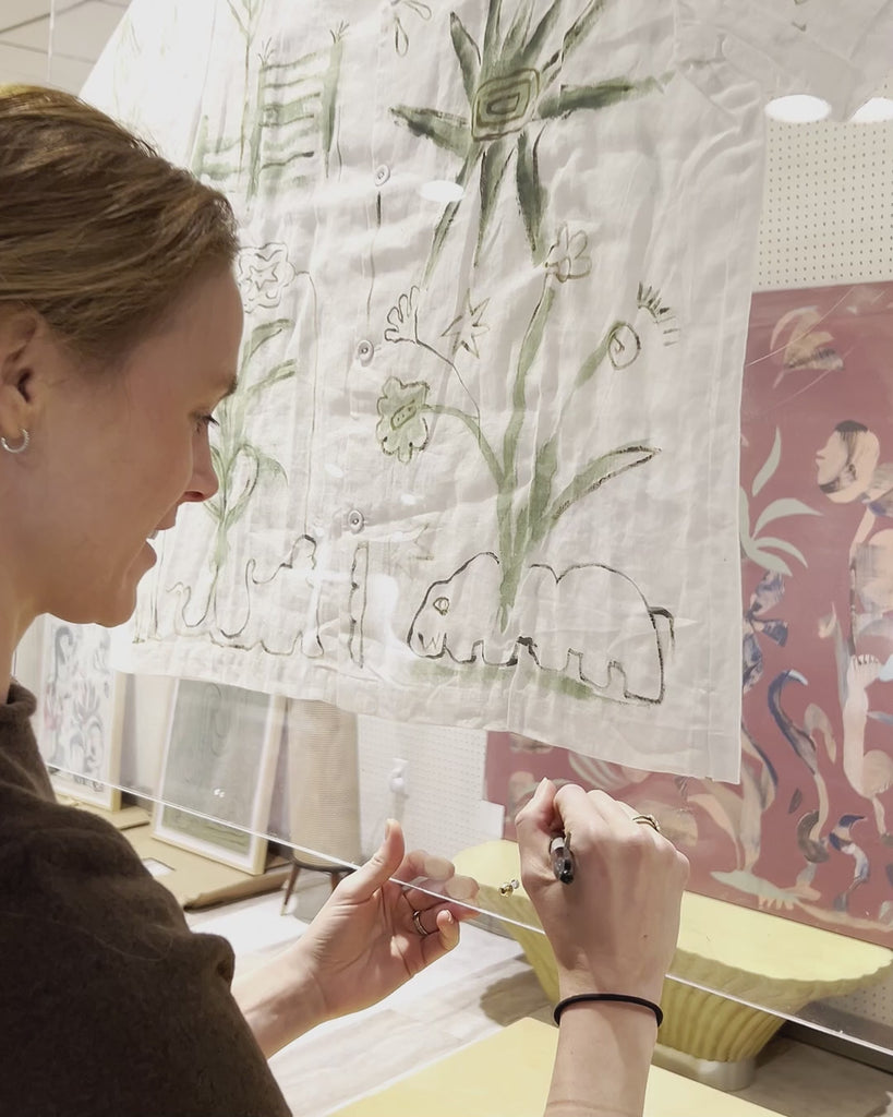 Video of artist Mary Ball signing her autograph on the bottom of the glass case displaying her work.