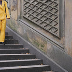 Woman walking downstairs, wearing the full Saffron Corduroy Easy Going Suit.